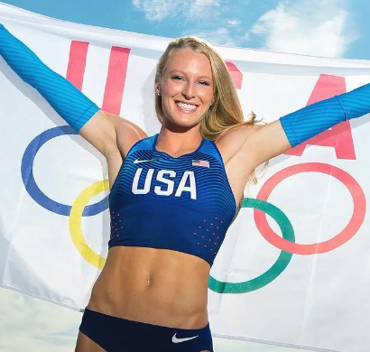 Sandi Morris Female athlete holding a USA flag and celebrating in front of Olympic rings