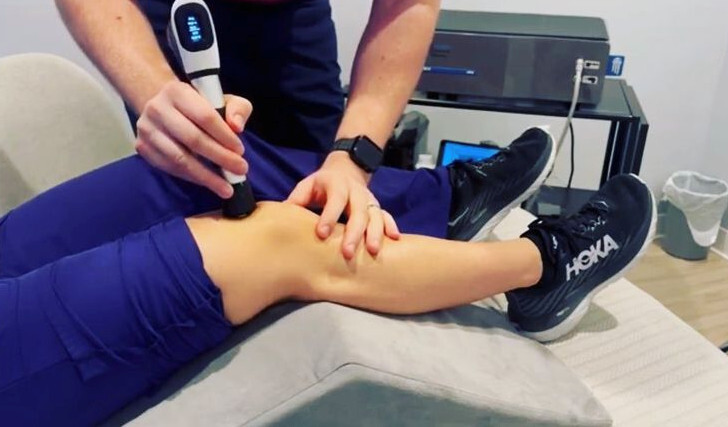 Chiropractor performing radial shockwave therapy on a patient’s knee to relieve joint pain and promote tissue healing at Spine Align Chiropractic & Wellness in Huntsville.