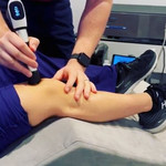 Chiropractor performing radial shockwave therapy on a patient’s knee to relieve joint pain and promote tissue healing at Spine Align Chiropractic & Wellness in Huntsville.