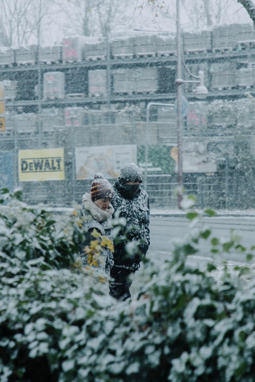 Two people walking outside in heavy snowfall