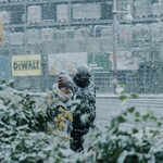 Two people walking outside in heavy snowfall