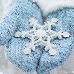 Blue mittens holding a snowflake in winte