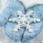 Blue mittens holding a snowflake in winte
