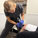 Chiropractor Applying Shockwave to the Knee of a Patient