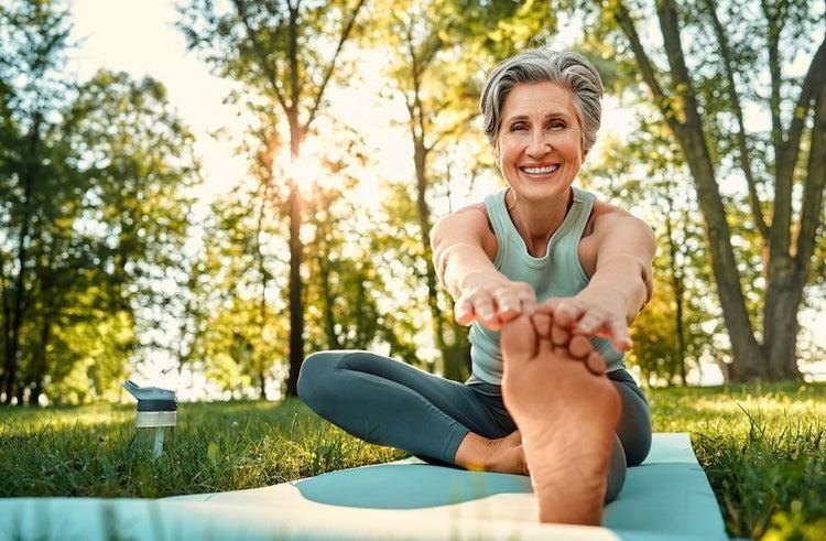 Active older woman stretching outdoors as part of a healthy lifestyle.